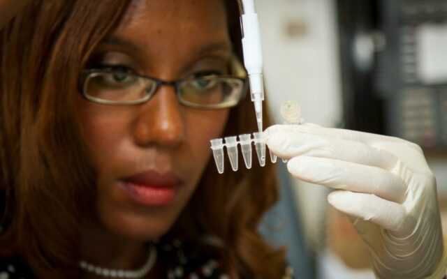 African scientist using a pipette to prepare samples during vaccine and biologics research
