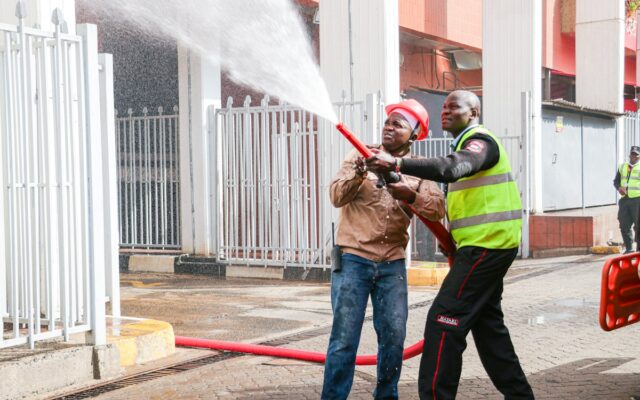Two men in safety gear conducting a fire hose training exercise
