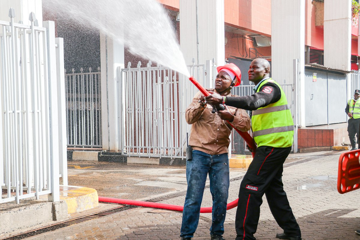 Two men in safety gear conducting a fire hose training exercise