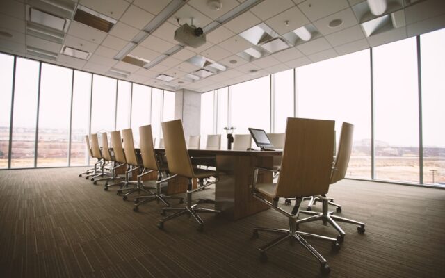 An empty formal boardroom with a long conference table