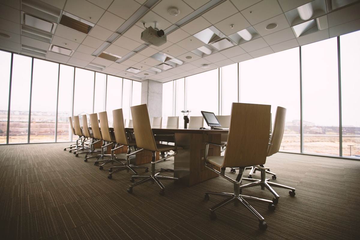 An empty formal boardroom with a long conference table