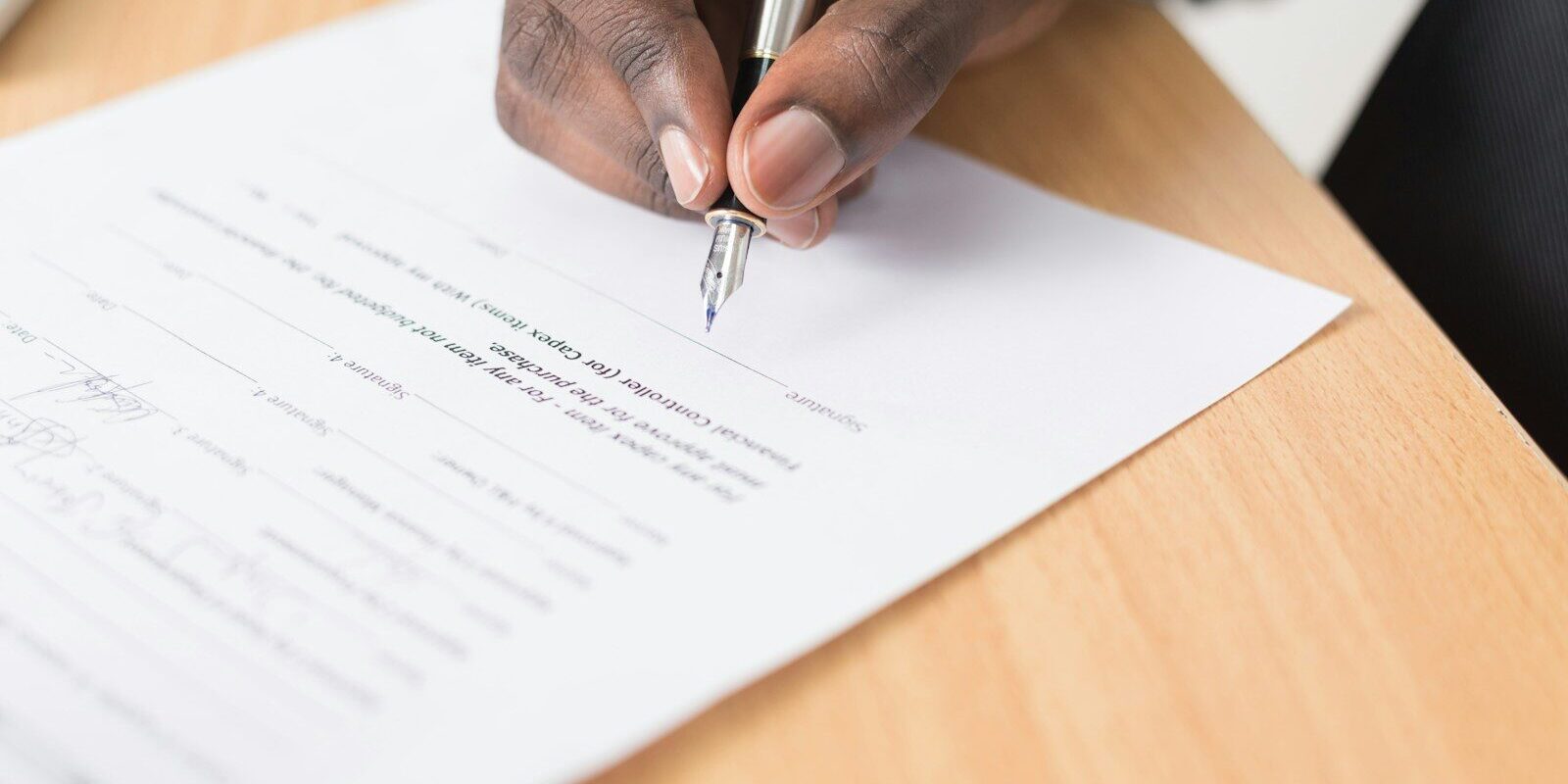 Hand signing a franchise agreement document in Kenya