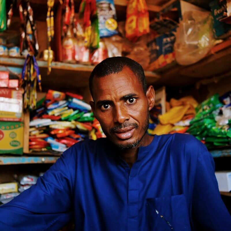 Kenyan shopkeeper surrounded by stocked inventory shelves, representing movable assets that can secure business credit