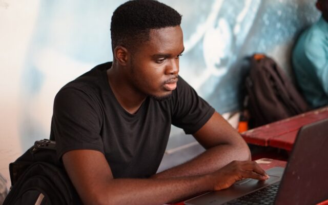 A man focused on his laptop screen responding to an urgent matter