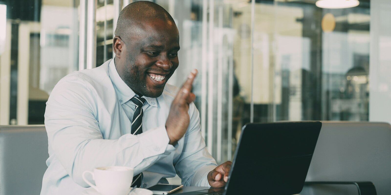 African business professional on a video call with his laptop in a modern office, representing non-resident digital businesses engaging Kenyan users