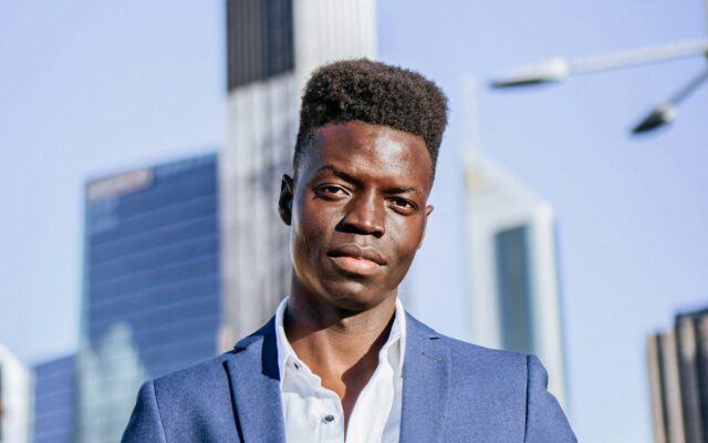 African businessman in a suit with a city financial district skyline behind him, representing private credit funds and alternative lending in Kenya