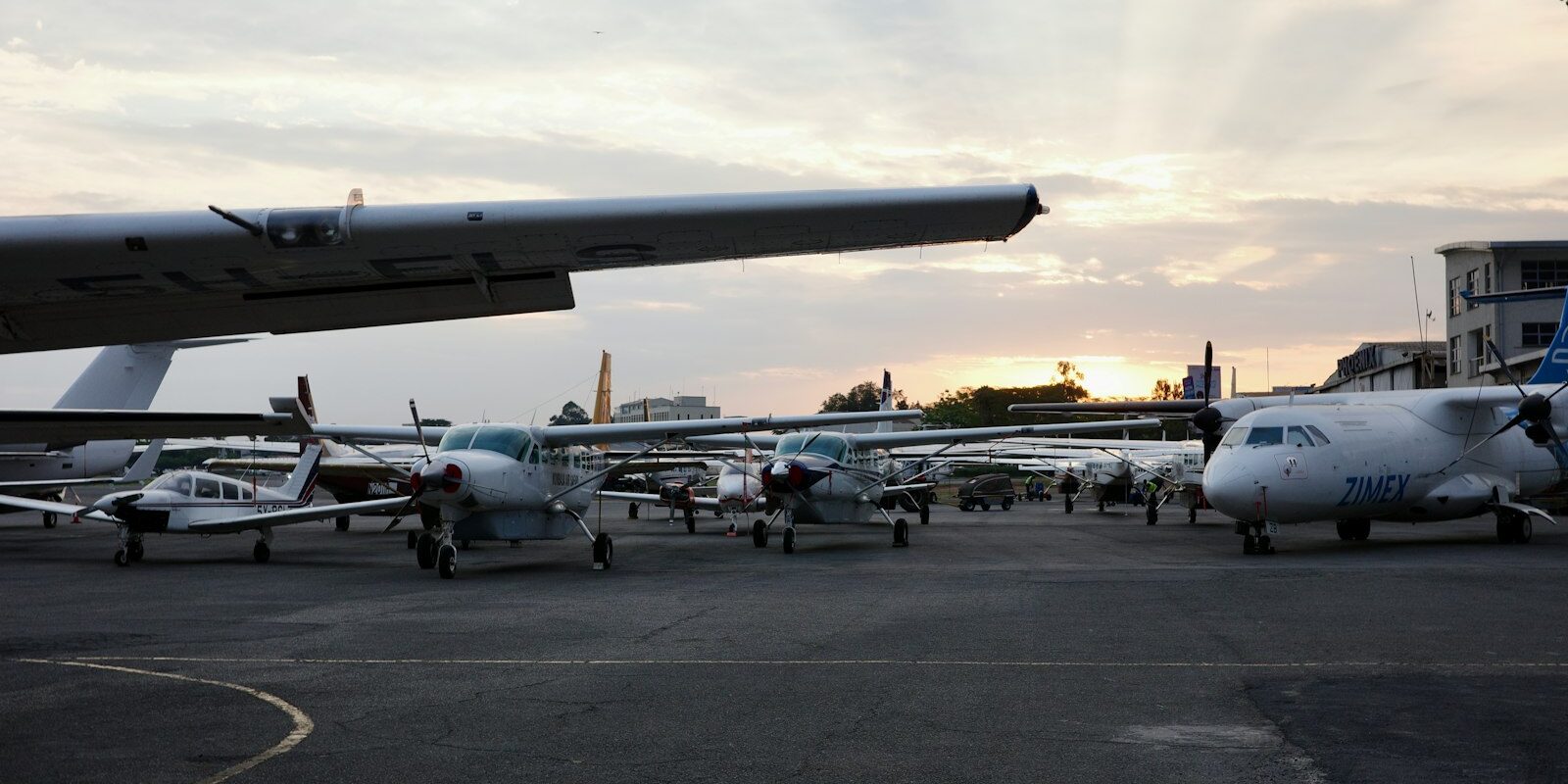 Small aircraft parked on an airport tarmac at sunset, representing Kenya's Air Passenger Service Charge Act