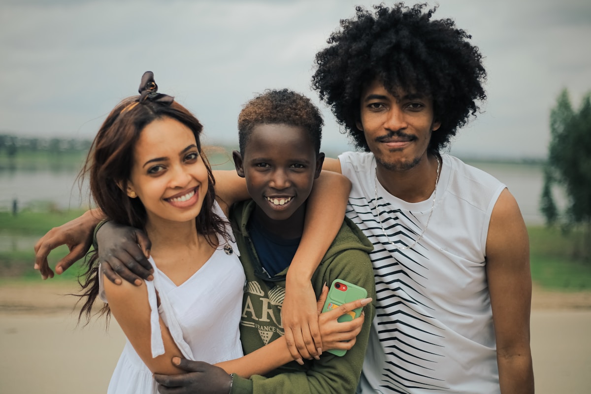 African family, parents and child, smiling together outdoors, representing a family relocating to Kenya for work under a Dependant's Pass