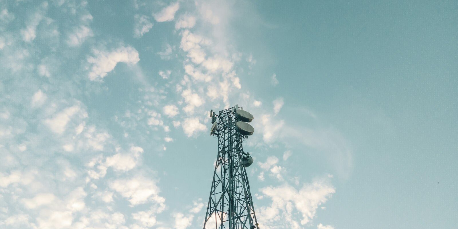 Telecommunications tower against a cloudy sky