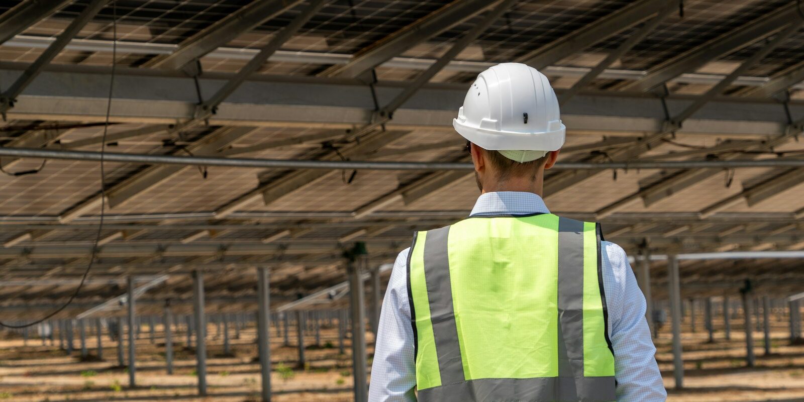 Solar engineer inspecting panels at a renewable energy plant