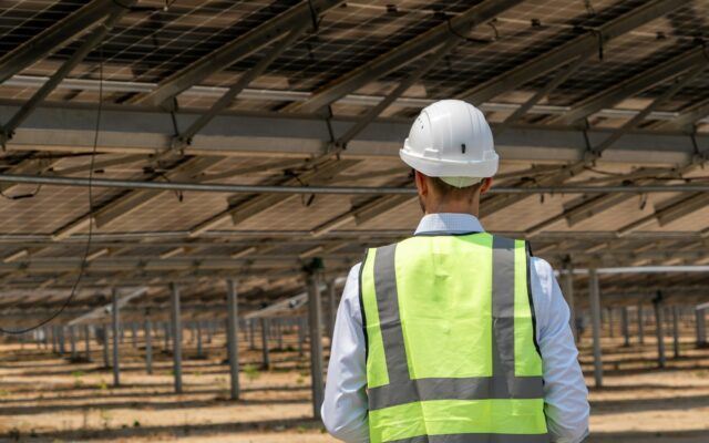 Solar engineer inspecting panels at a renewable energy plant