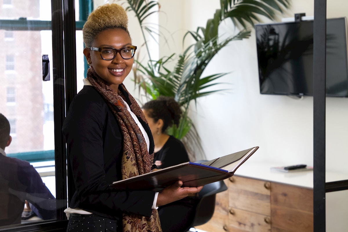 African businesswoman in a modern Nairobi office holding a folder, representing a foreign investor navigating Kenya's investment promotion apparatus