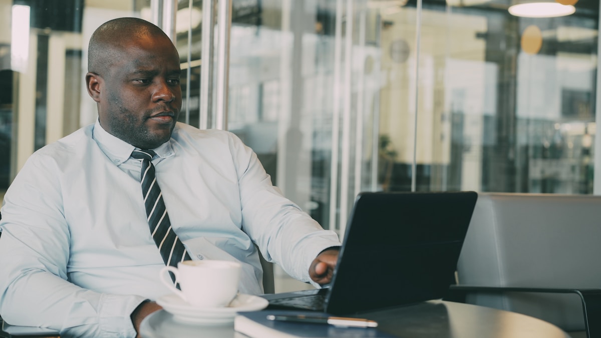 African business professional working on a laptop in a modern office, representing a foreign investor evaluating Special Economic Zone eligibility in Kenya