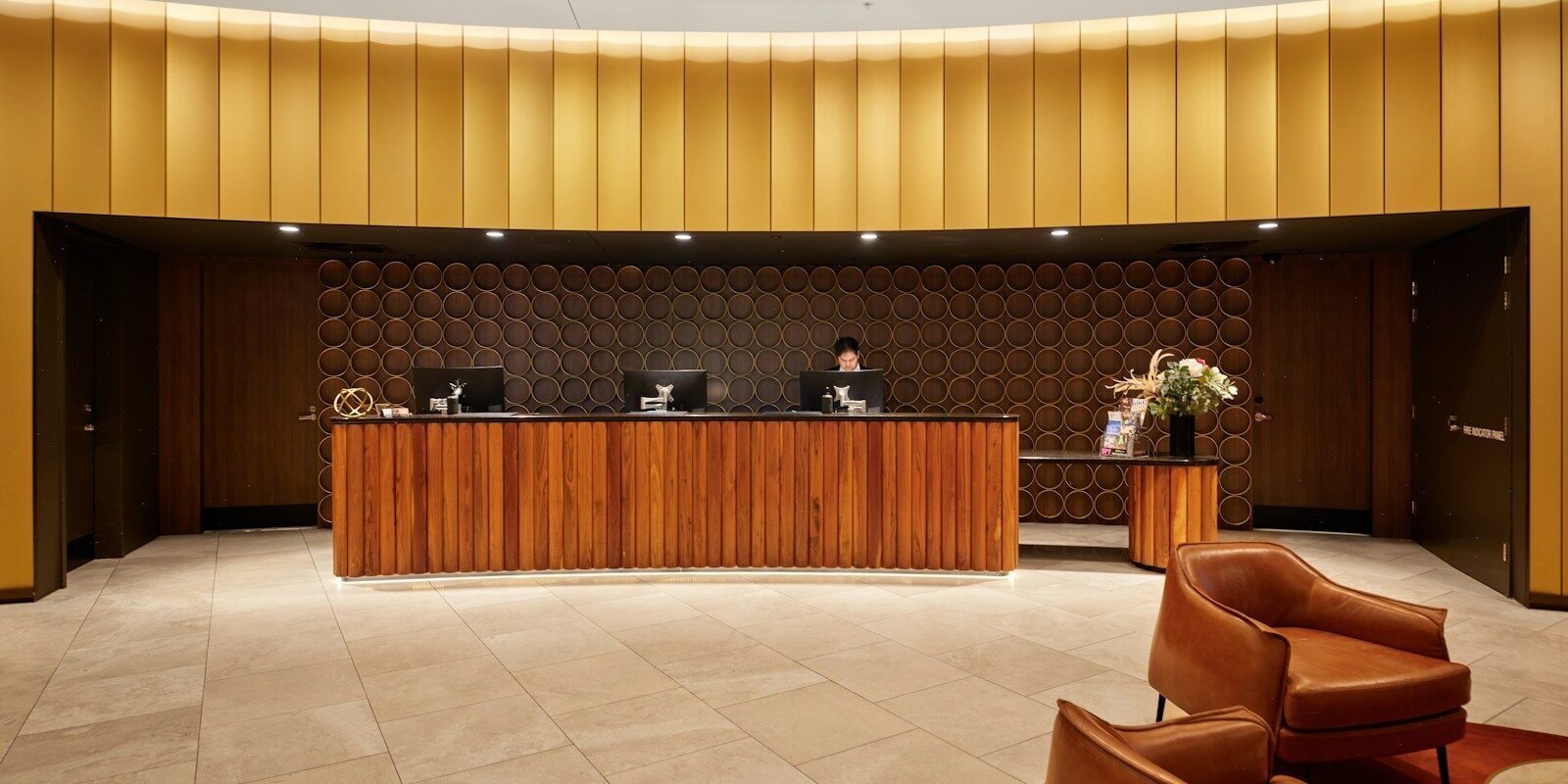 Hotel management agreements: hotel reception lobby with a curved wooden front desk, representing a branded hotel run by a foreign operator