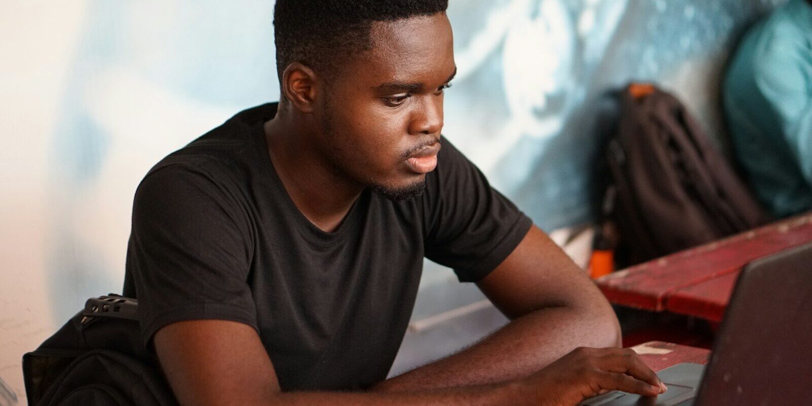 Training AI on copyrighted works in Kenya: young African developer working on a laptop, representing a team assembling a training dataset