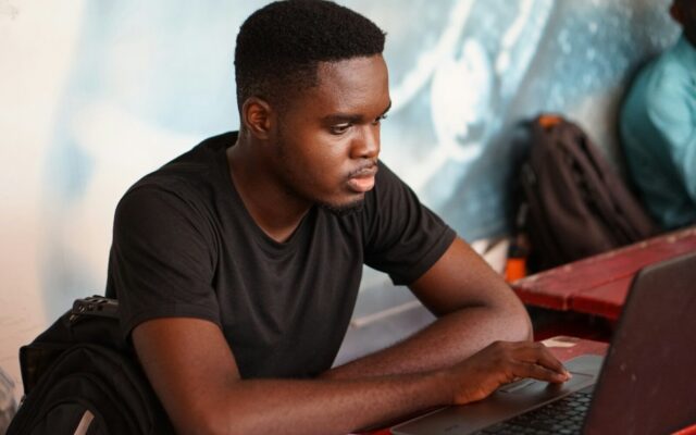 Training AI on copyrighted works in Kenya: young African developer working on a laptop, representing a team assembling a training dataset