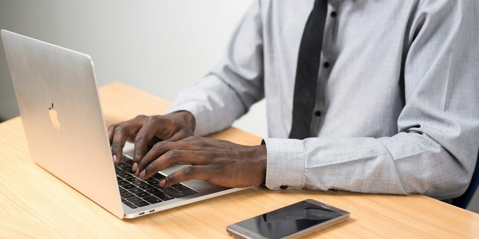 A professional working on a laptop at a desk, representing the careful review of trademark filing details before submission to KIPI.