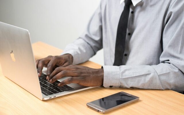 A professional working on a laptop at a desk, representing the careful review of trademark filing details before submission to KIPI.