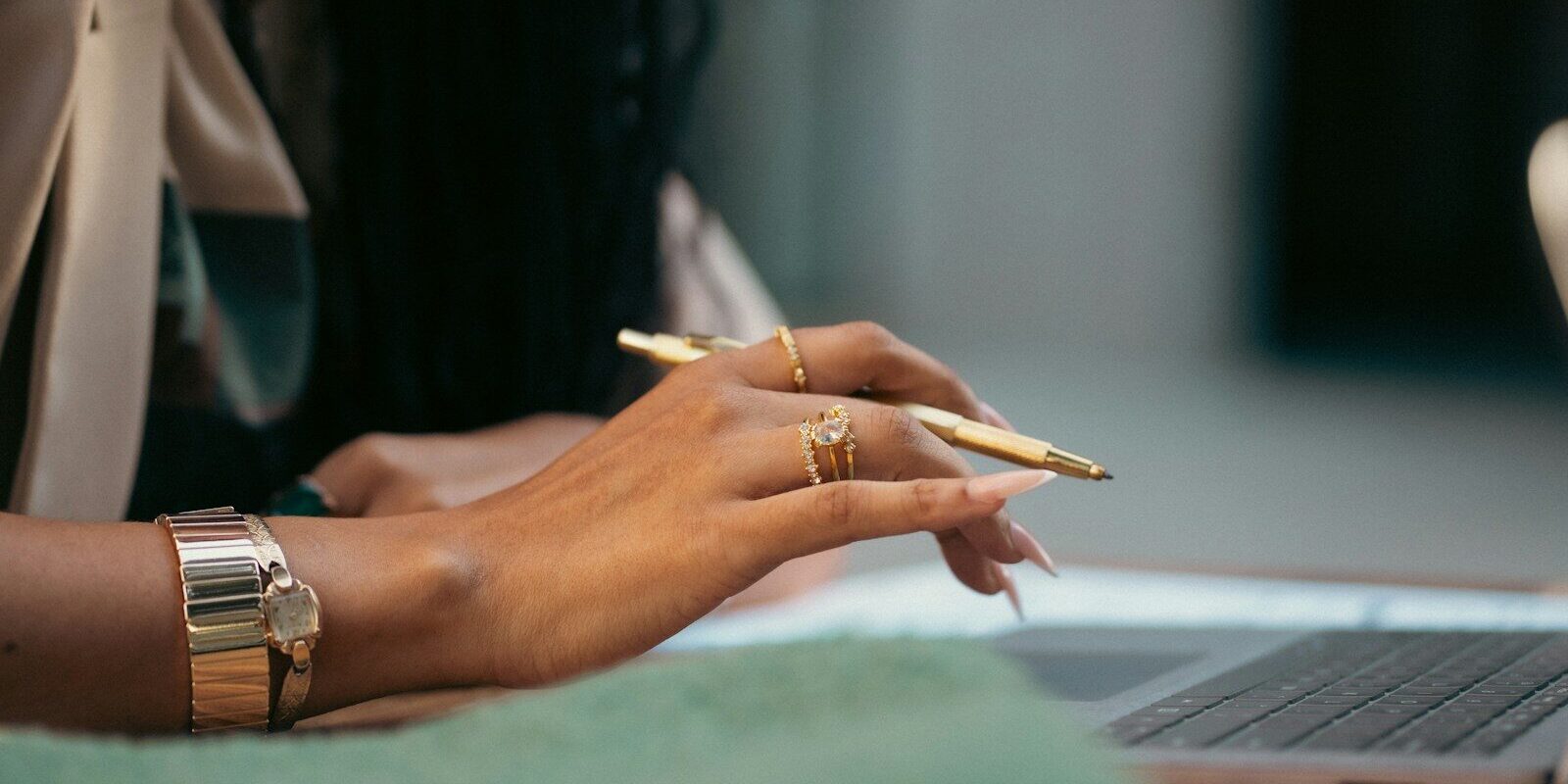 Company name reservation versus trademark protection: African businesswoman with gold pen and laptop reviewing brand name records