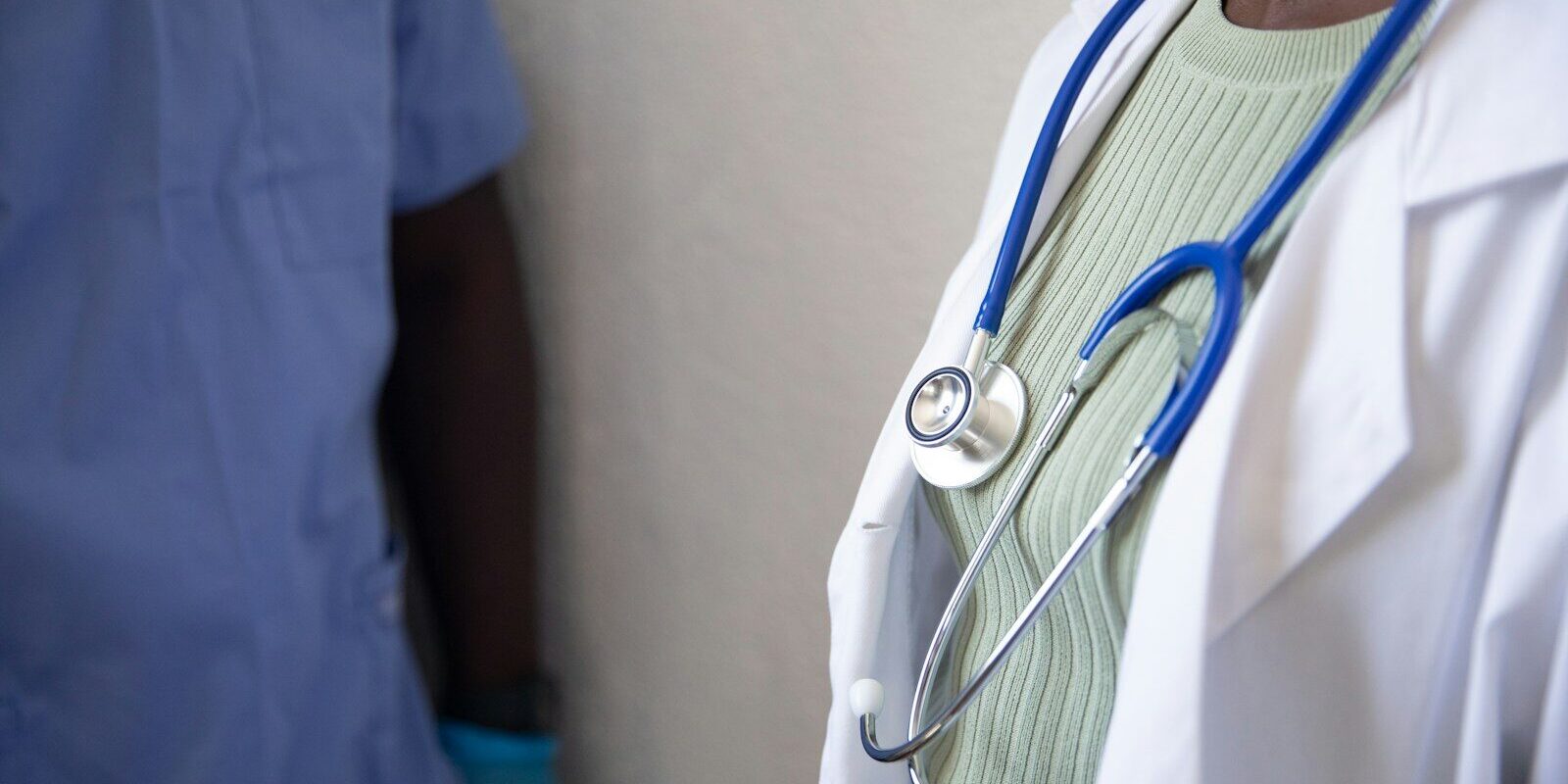 African doctor with a stethoscope consulting a patient in a clinical setting