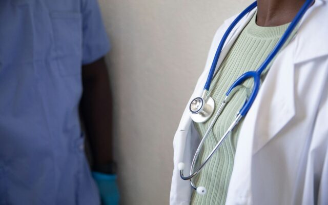 African doctor with a stethoscope consulting a patient in a clinical setting