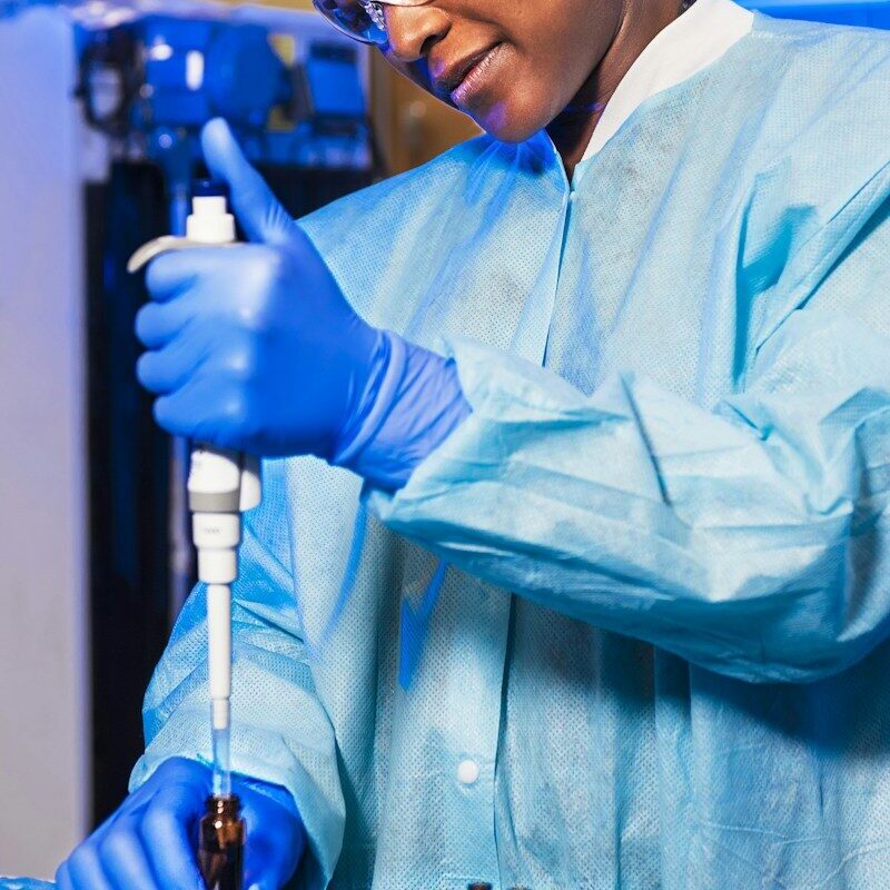 African laboratory scientist using a precision pipette to calibrate sample measurements