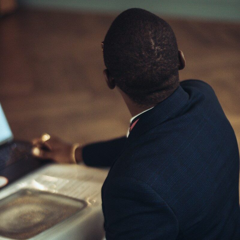 Trademark change of name and address at KIPI: African professional at a laptop updating trademark register records