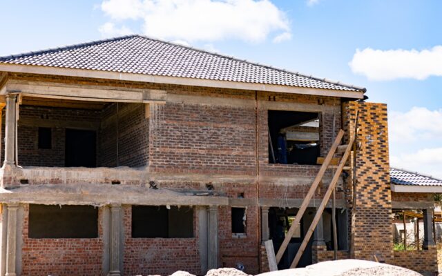 Two-storey brick house under construction illustrating an off-plan property purchase in Kenya
