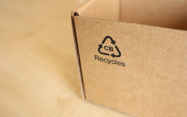A cardboard box printed with a recycling symbol and claim
