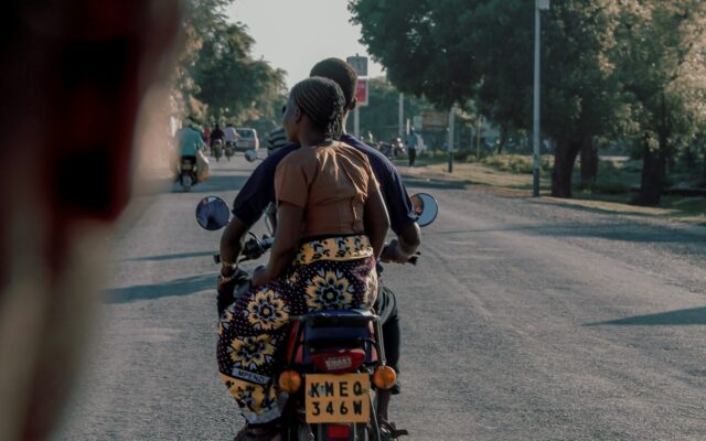 Motorcycle taxi carrying a passenger on a Kenyan road