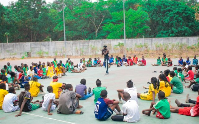 Adult addressing a group of young people representing safeguarding duties for child athletes in Kenya