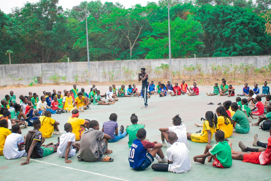 Adult addressing a group of young people representing safeguarding duties for child athletes in Kenya