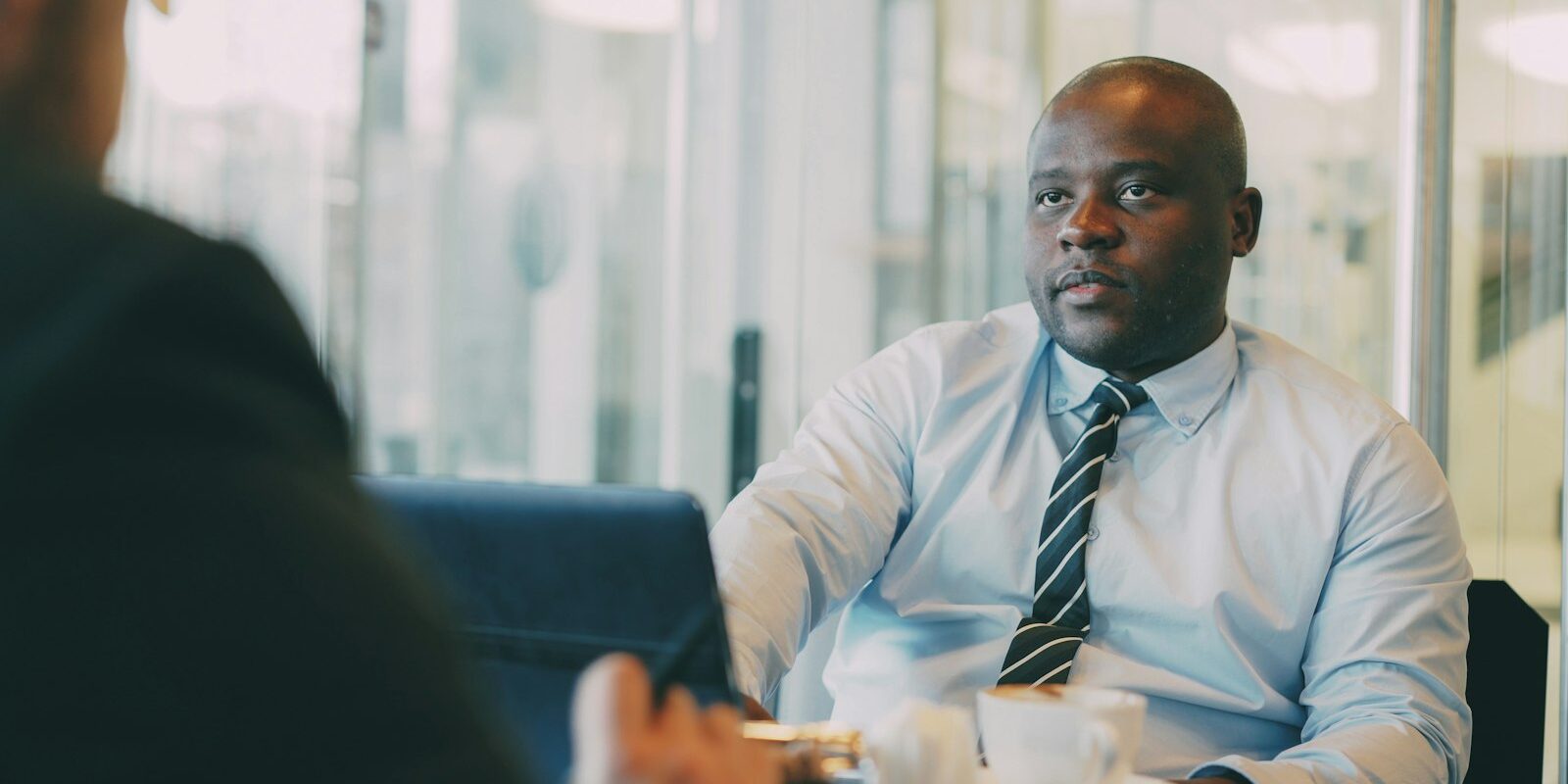 African manager in a meeting discussing a secondment to Kenya and the employer of a seconded expatriate