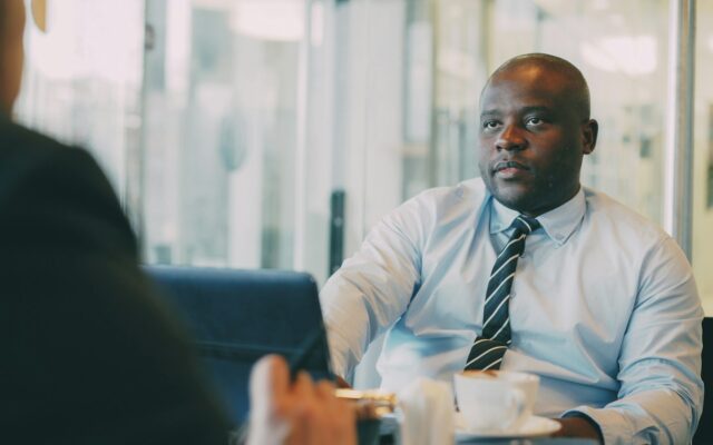 African manager in a meeting discussing a secondment to Kenya and the employer of a seconded expatriate
