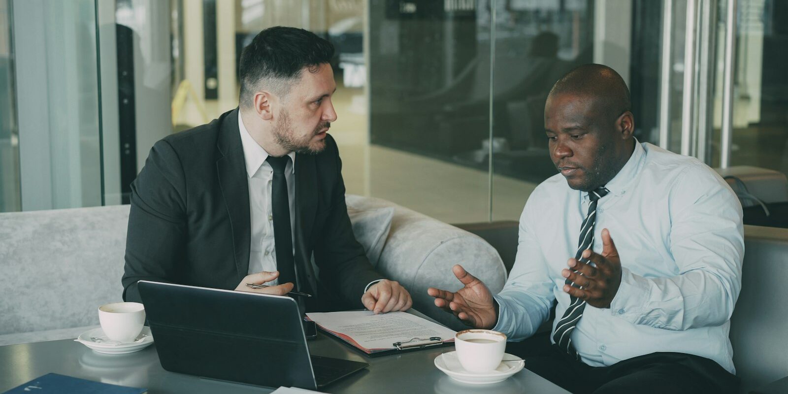 Two professionals discussing a show cause letter in Kenya at an office table