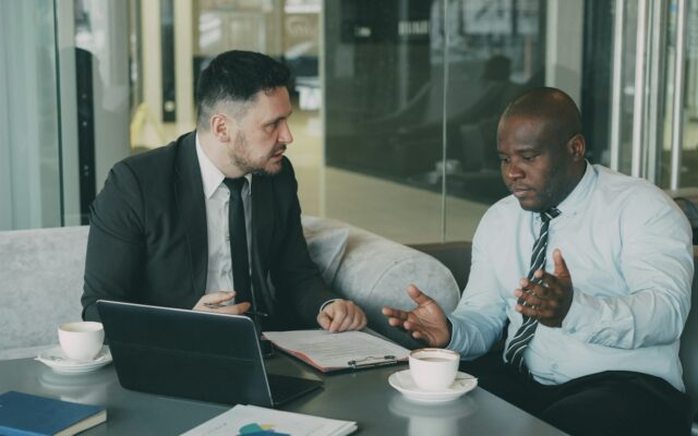 Two professionals discussing a show cause letter in Kenya at an office table