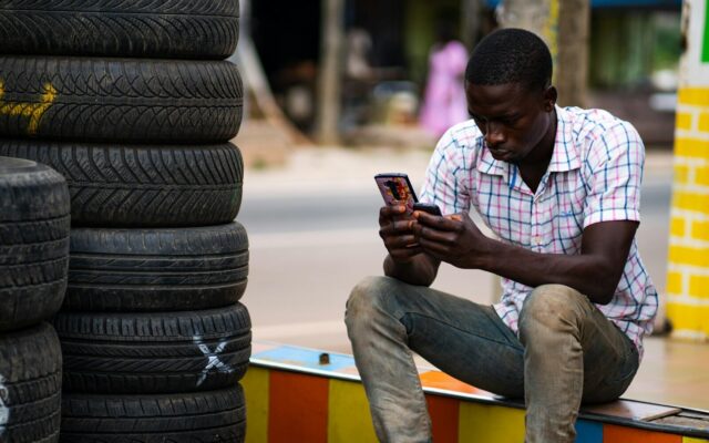 Kenyan digital lending customer checking a mobile phone, illustrating algorithmic credit scoring in everyday borrowing