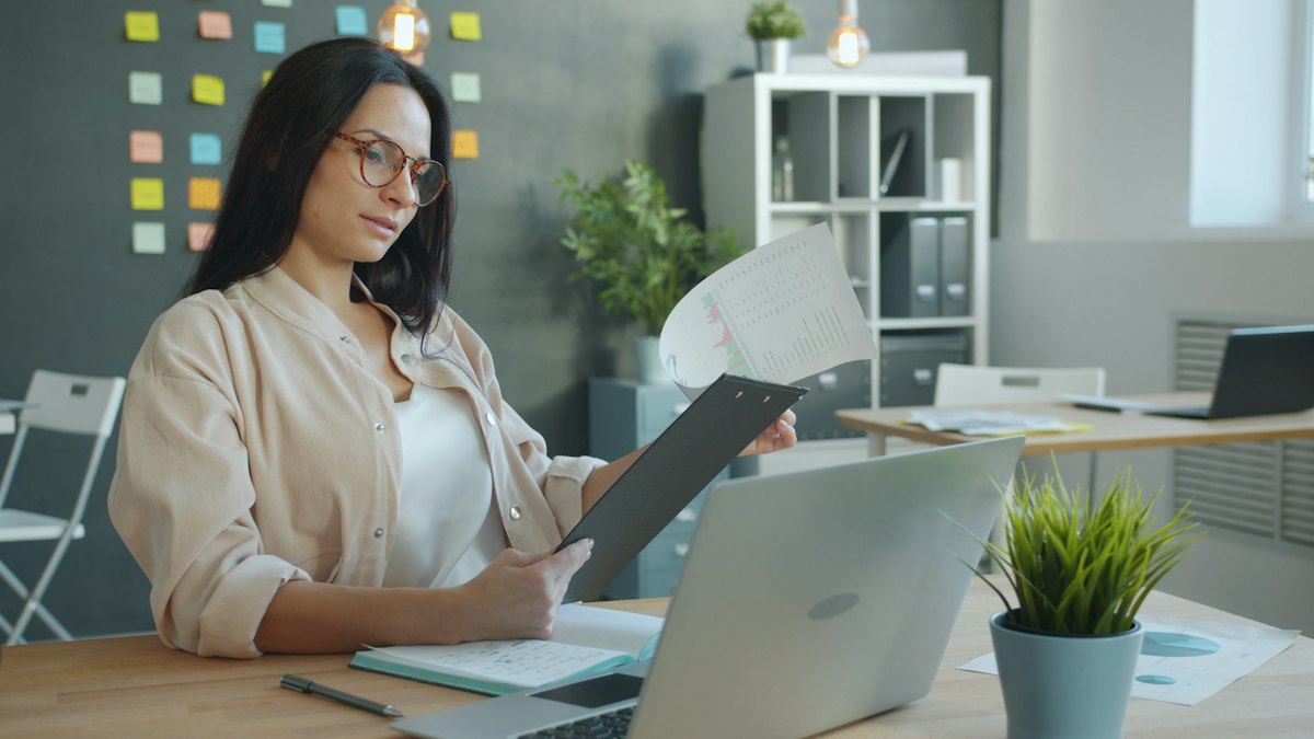 A business owner reviewing documents at her office desk