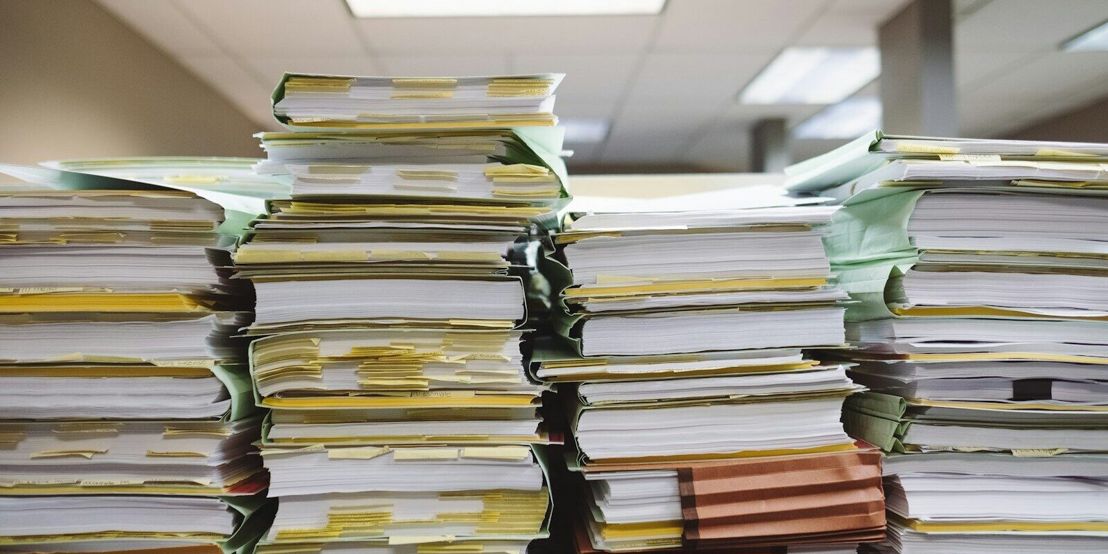 Stacks of case files and documents in a law office, representing the paper trail behind a debt recovery claim.