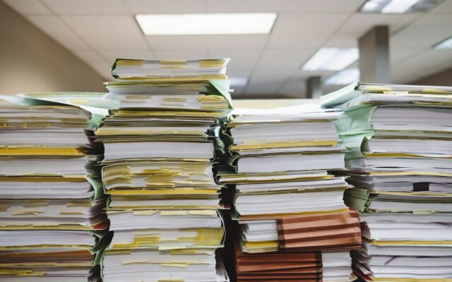 Stacks of case files and documents in a law office, representing the paper trail behind a debt recovery claim.