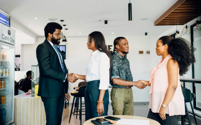 African business professionals shaking hands after concluding a deal in a cafe