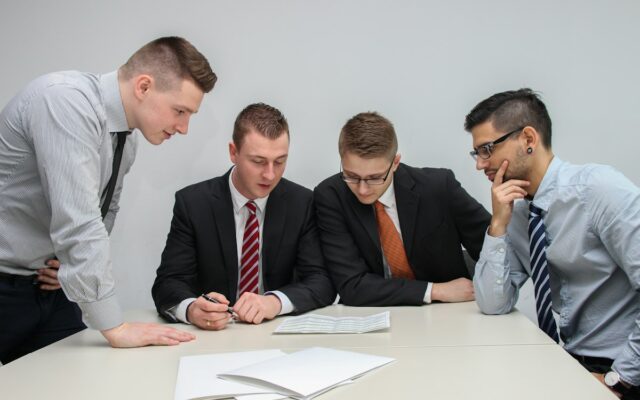 A group of businessmen reviewing a document together at a table