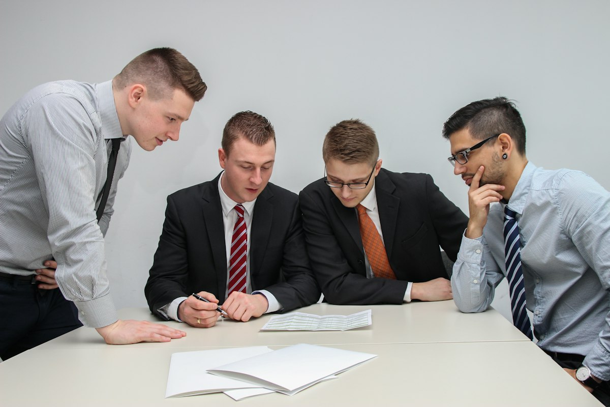 A group of businessmen reviewing a document together at a table