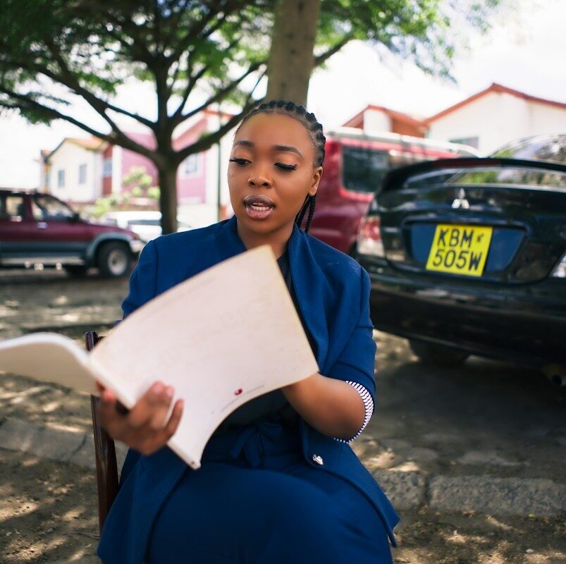 Removal for non-use: Kenyan businesswoman in a blue suit reviewing trademark use documents in Nairobi