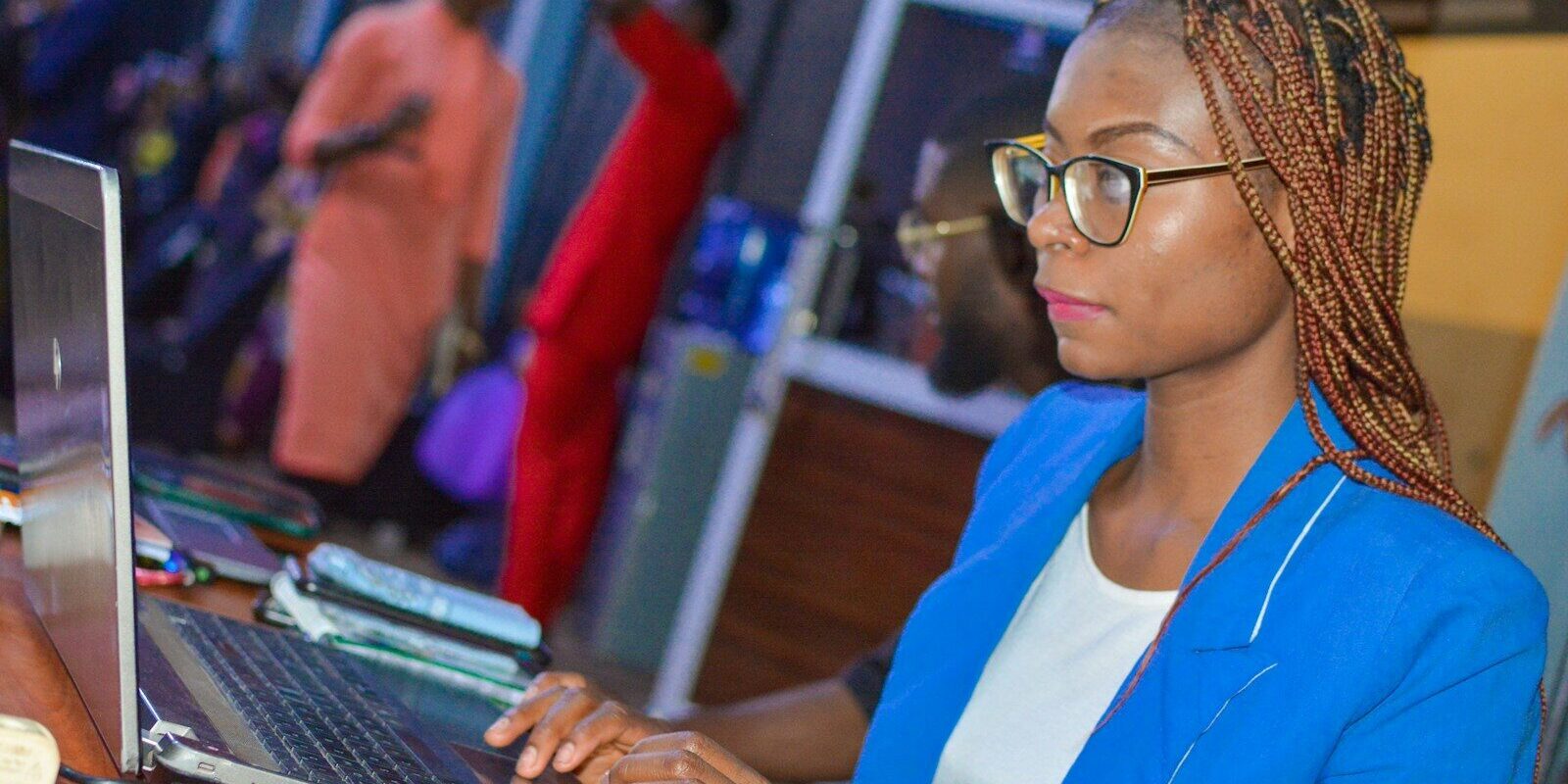 An African businesswoman typing on a laptop at an office desk, representing data protection and registration compliance
