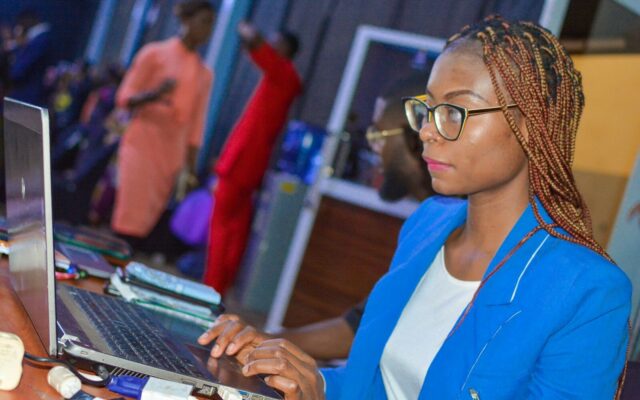 An African businesswoman typing on a laptop at an office desk, representing data protection and registration compliance
