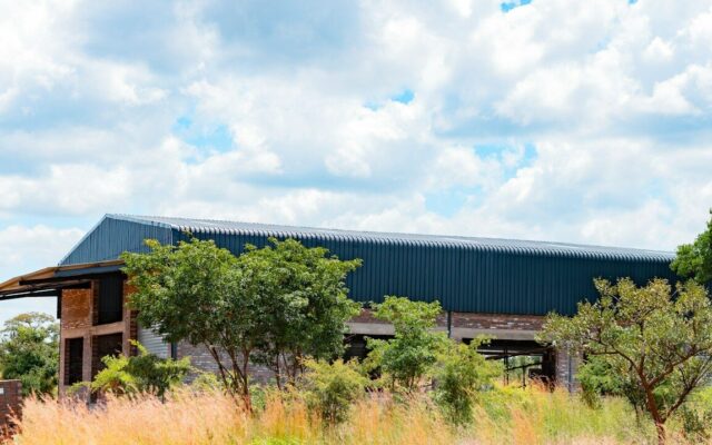Newly built agricultural warehouse with a corrugated metal roof in rural Kenya, representing a licensed warehouse operator under the Warehouse Receipt System Act