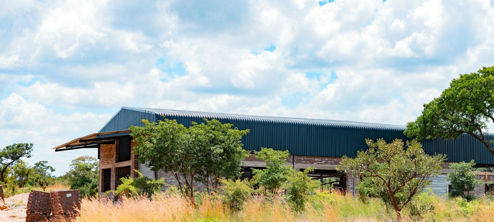 Newly built agricultural warehouse with a corrugated metal roof in rural Kenya, representing a licensed warehouse operator under the Warehouse Receipt System Act