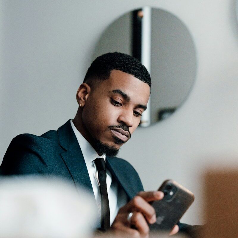 African businessman reviewing project agreement documents on his phone, representing green hydrogen project structuring in Kenya