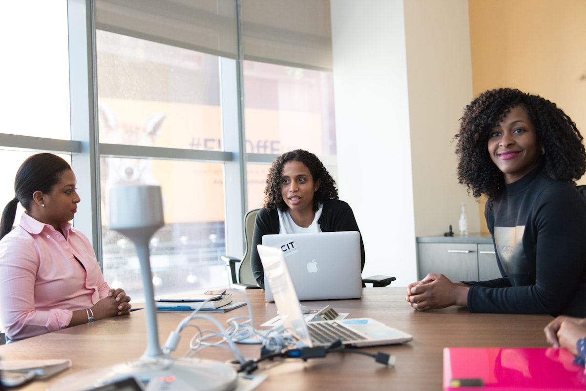 Three colleagues in a meeting reviewing a laptop